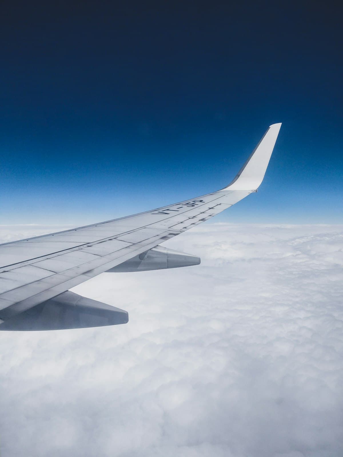 An aircraft wing above a bright cloud layer at cruise altitude