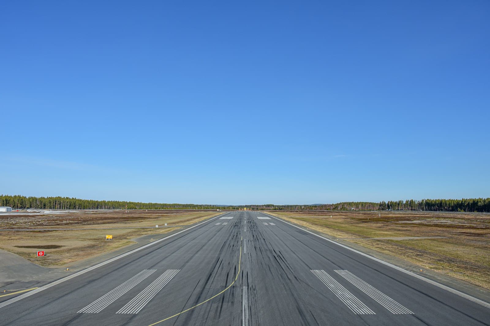 A runway seen head-on under a clear blue sky