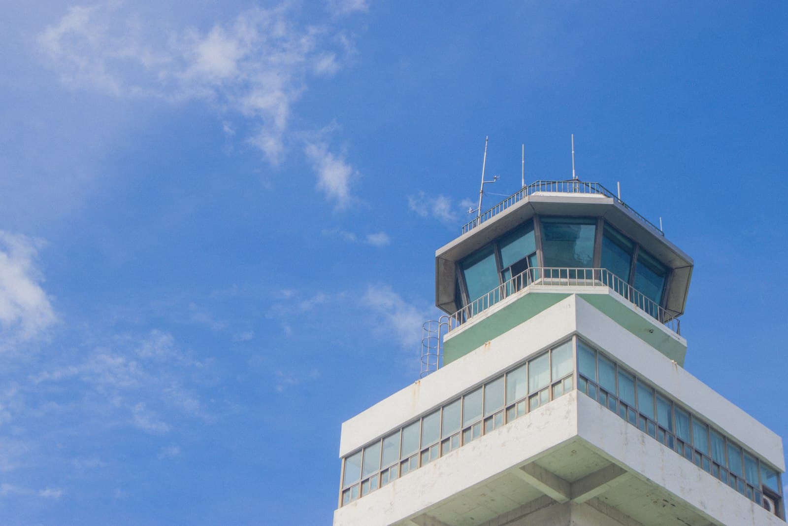 An airport control tower against a bright blue sky